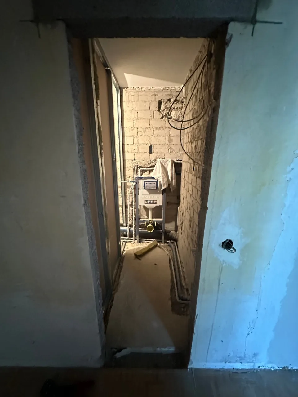 Vorher: WC-Raum mit sichtbaren Installationen im Ausbau
