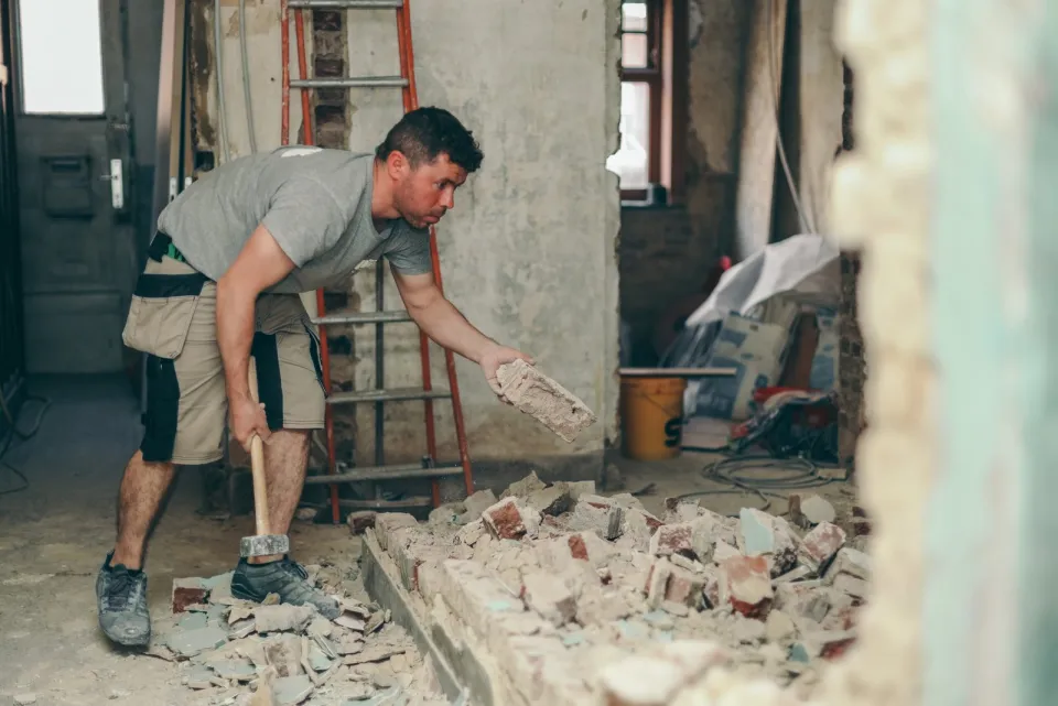 Handwerker beim Räumen von Mauerwerk und Bauschutt